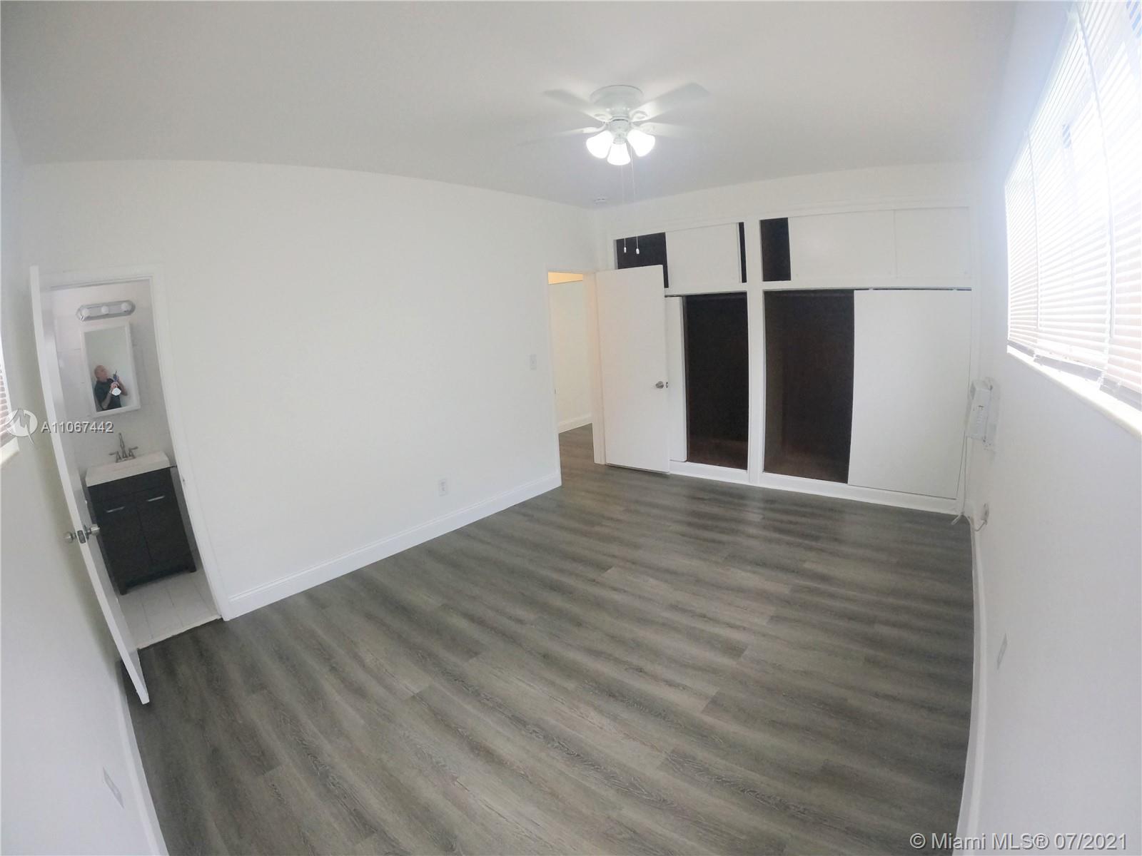 809 85th Street Miami Beach, FL 33141 - Photo 17 of 32 a view of an empty room with wooden floor and a window