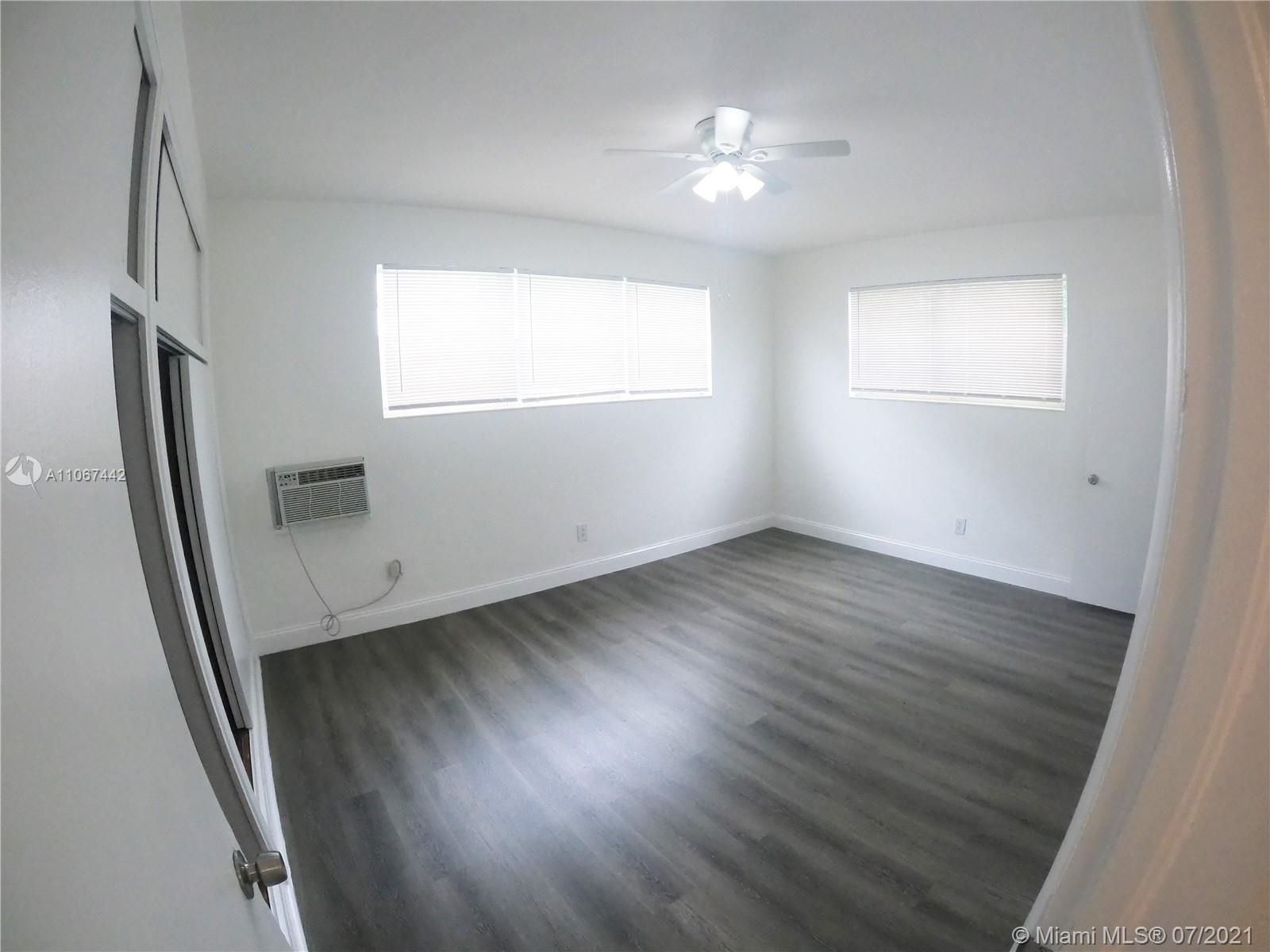 809 85th Street Miami Beach, FL 33141 - Photo 18 of 32 an empty room with wooden floor and windows