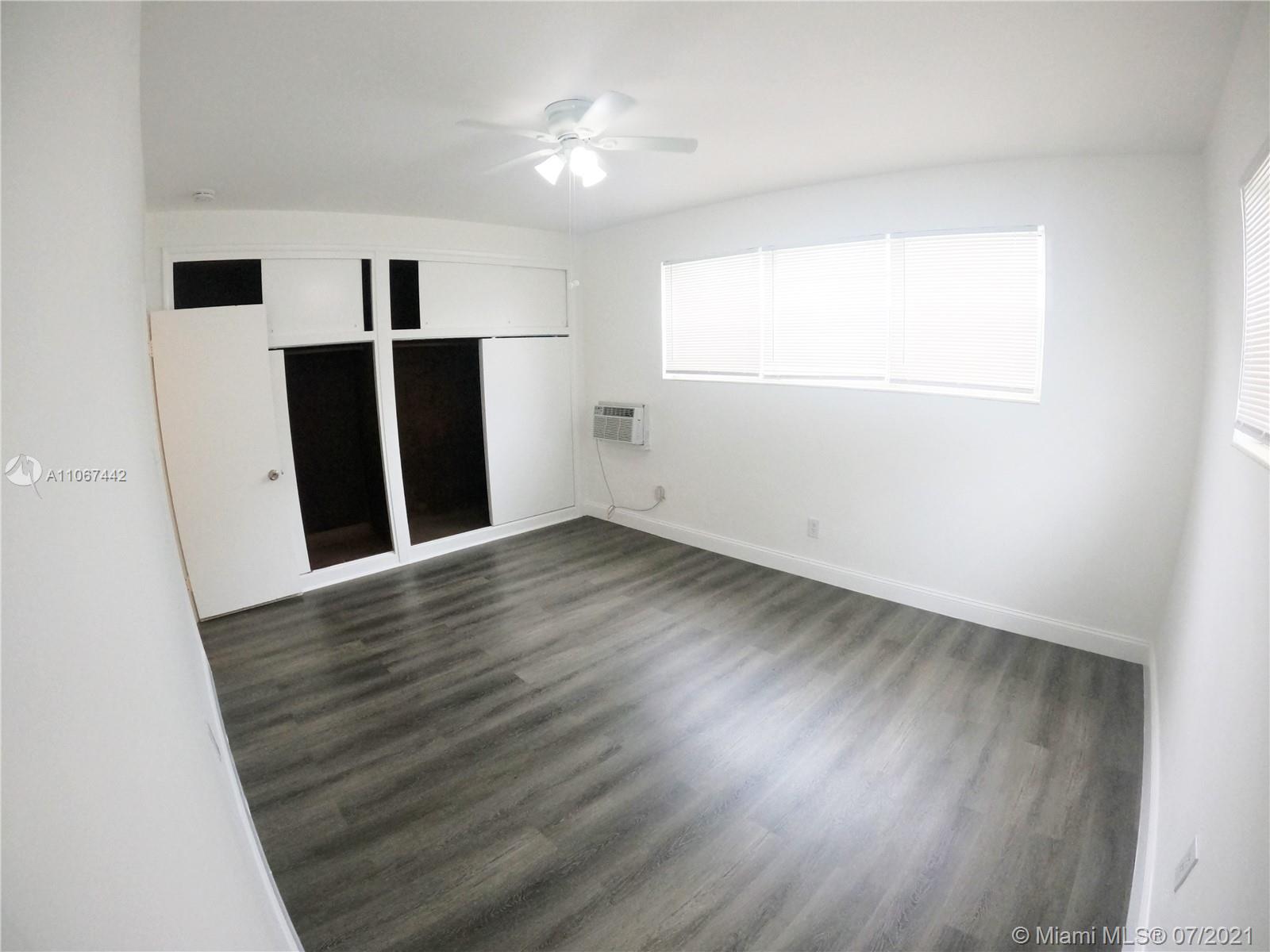 809 85th Street Miami Beach, FL 33141 - Photo 19 of 32 an empty room with wooden floor and window