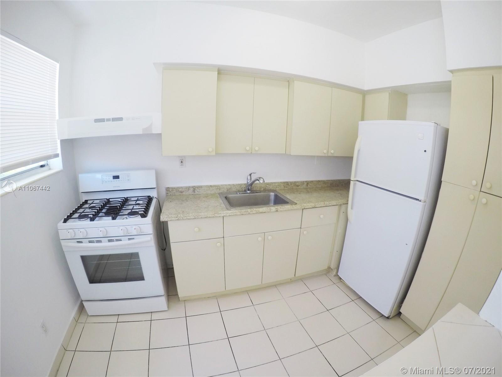 809 85th Street Miami Beach, FL 33141 - Photo 3 of 32 a kitchen with a stove a refrigerator and a sink