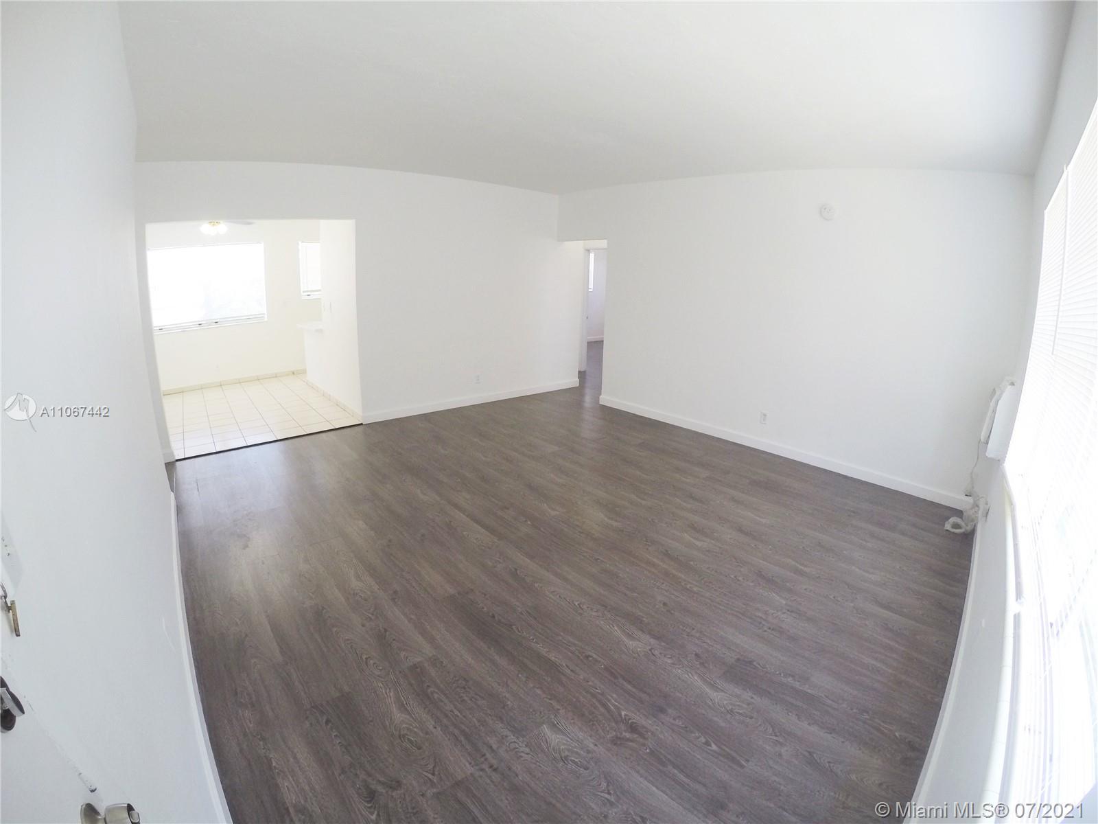809 85th Street Miami Beach, FL 33141 - Photo 6 of 32 an empty room with wooden floor and windows