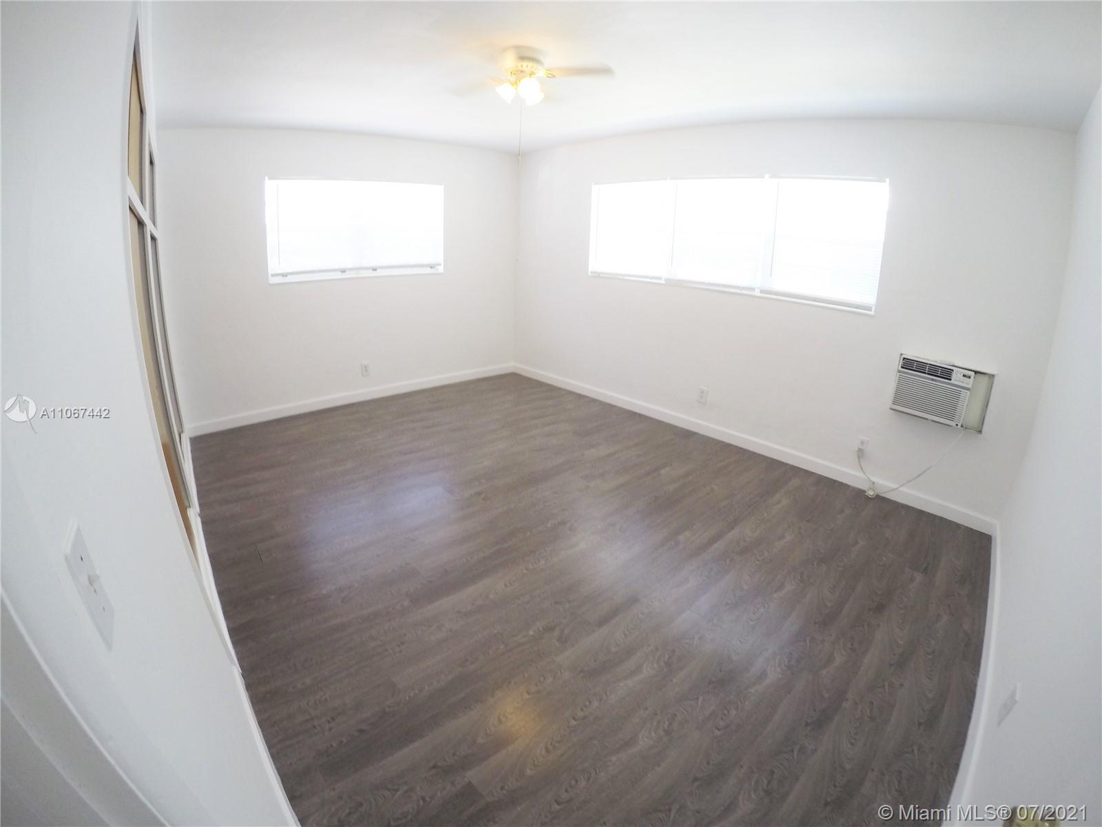 809 85th Street Miami Beach, FL 33141 - Photo 9 of 32 an empty room with wooden floor and windows