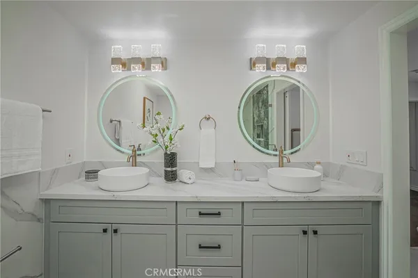 a bathroom with double vanity sinks and a mirror