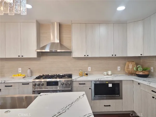 a kitchen with stainless steel appliances a stove a sink and cabinets