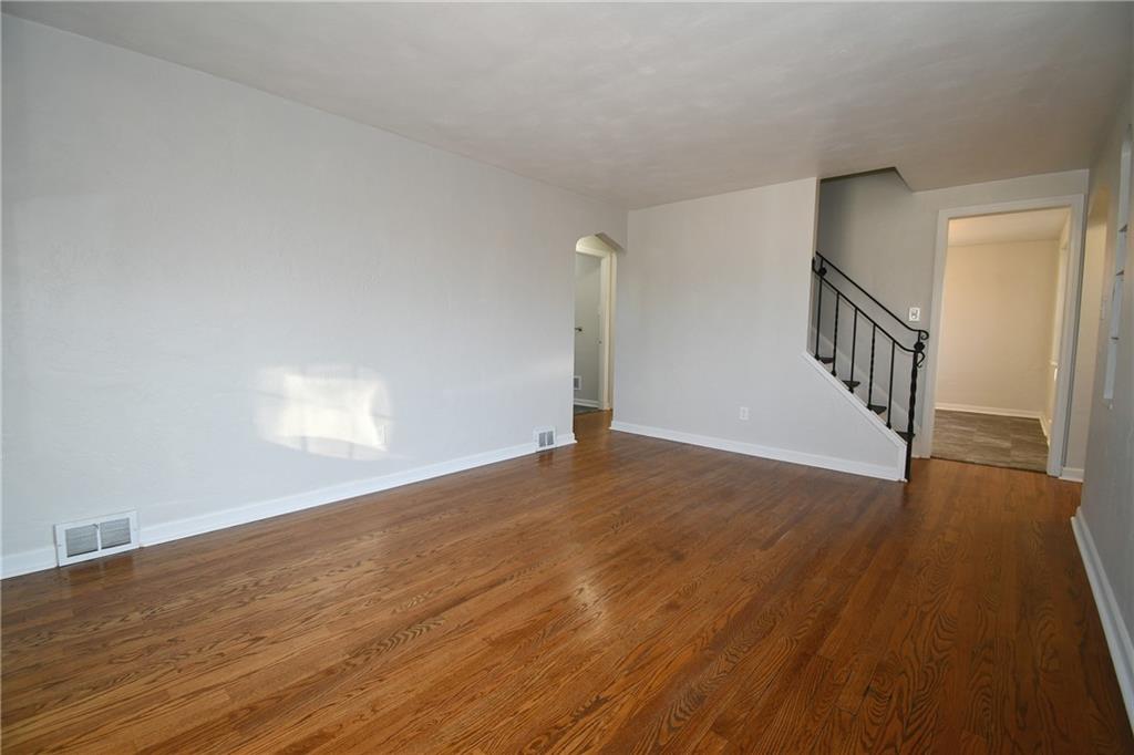 217 Oaklyn Road Bethel Park, PA 15102 - Photo 27 of 42 a view of an empty room with wooden floor and stairs