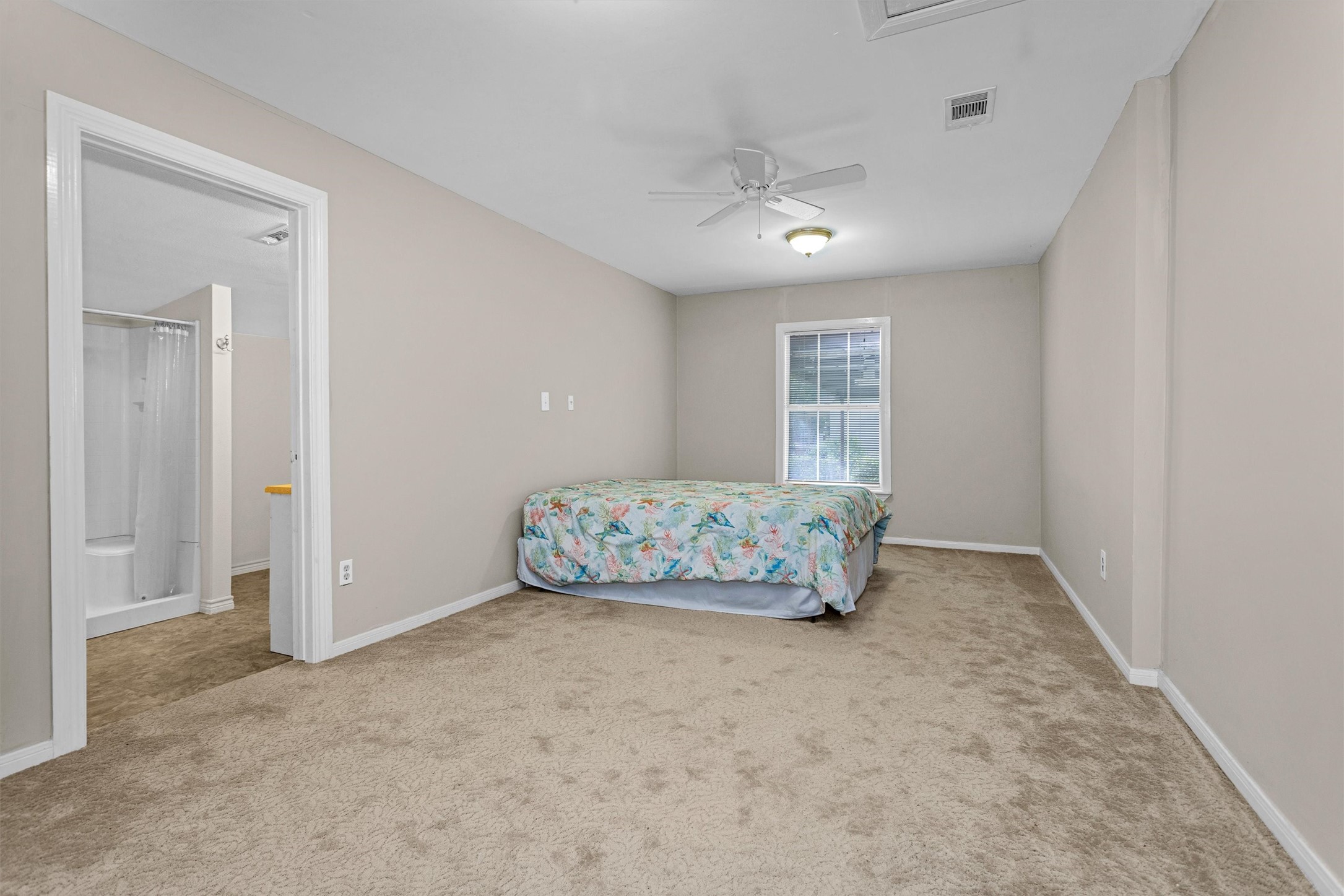 99 Main Street Huntsville, TX 77340 - Photo 21 of 47 The primary bedroom is spacious with an ensuite bathroom.