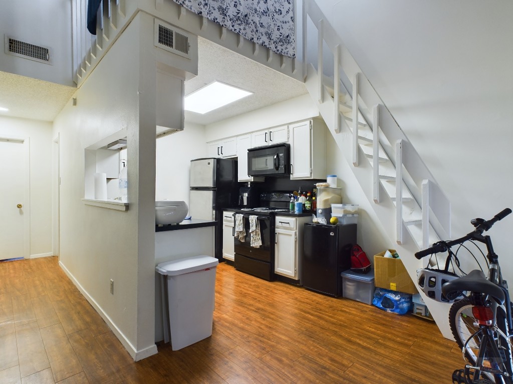 908 Poplar Street, Unit 201 Austin, TX 78705 - Photo 3 of 14 a view of living room kitchen with furniture and wooden floor