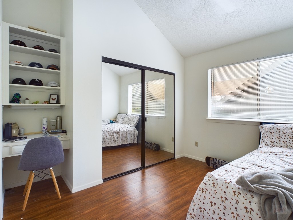 908 Poplar Street, Unit 201 Austin, TX 78705 - Photo 10 of 14 a bedroom with a bed and a chair