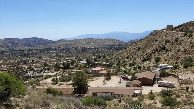 an aerial view of a house with a mountain view in back