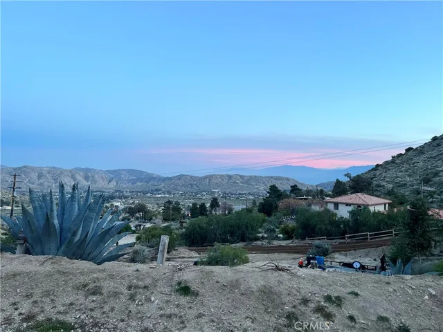 a view of a large house with a mountain and a forest