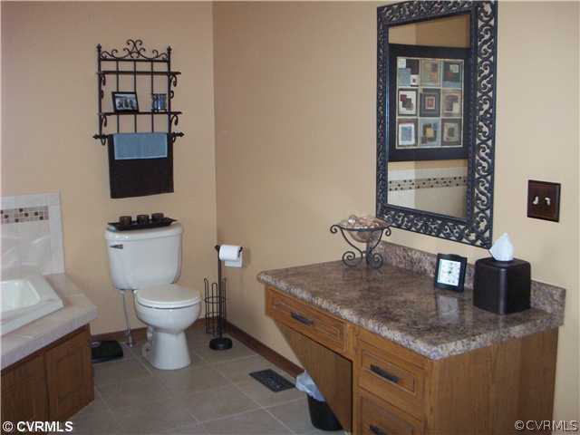 8244 White Oak Road Ford, VA 23850 - Photo 11 of 24 a bathroom with a granite countertop toilet sink and mirror