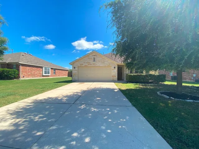 a front view of a house with a yard and garden