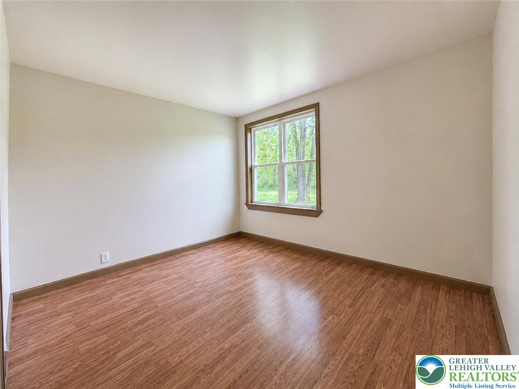 4995 Mountain Road Slatington, PA 18080 - Photo 17 of 30 A well-lit room awaits your personal touch, featuring gleaming laminate flooring and a garden view.
