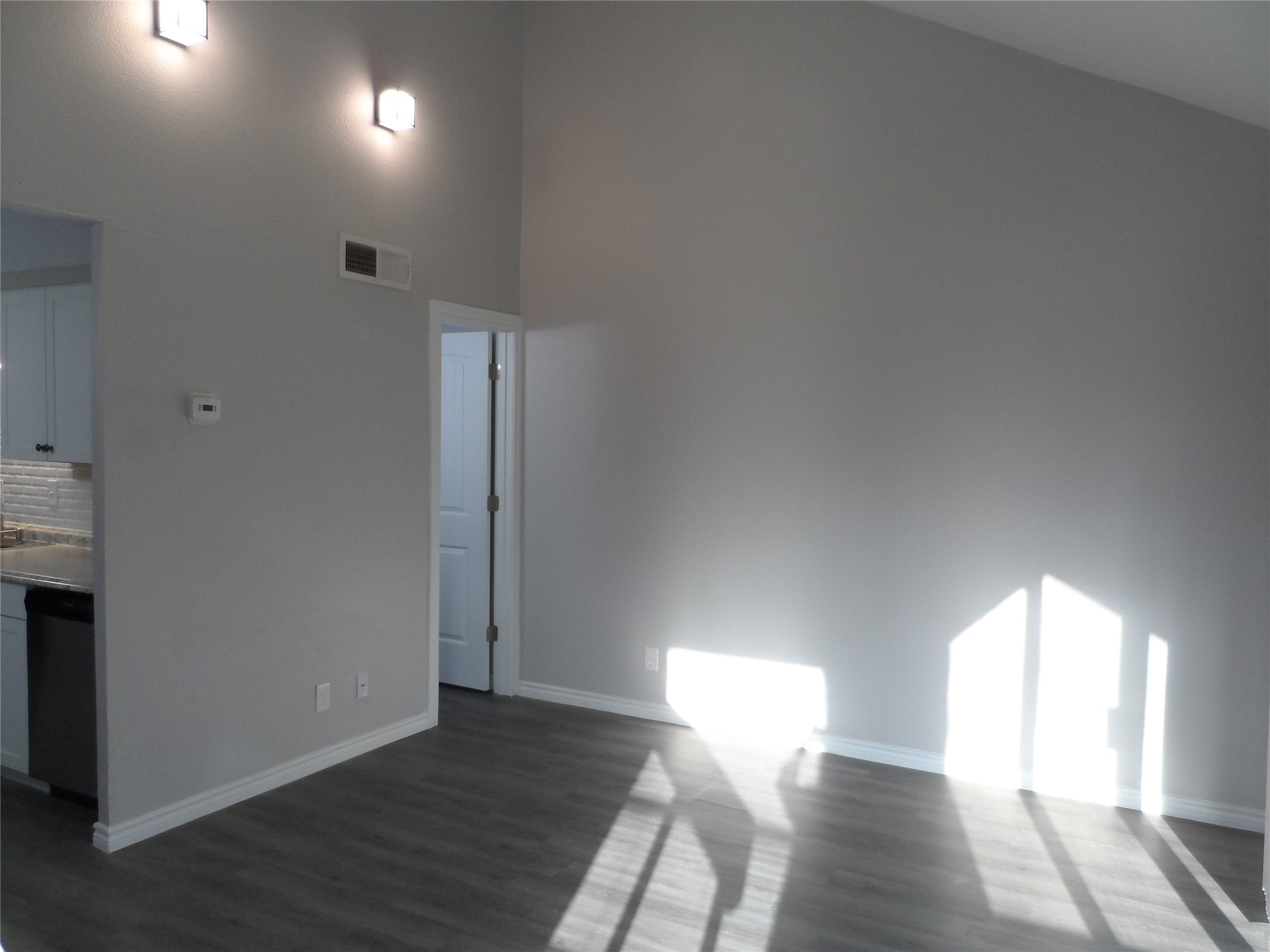 12900 Walden Road, Unit 618F Montgomery, TX 77356 - Photo 6 of 12 Spacious living area with vaulted ceiling, modern lighting, and wood-look flooring, offering an open and airy feel.