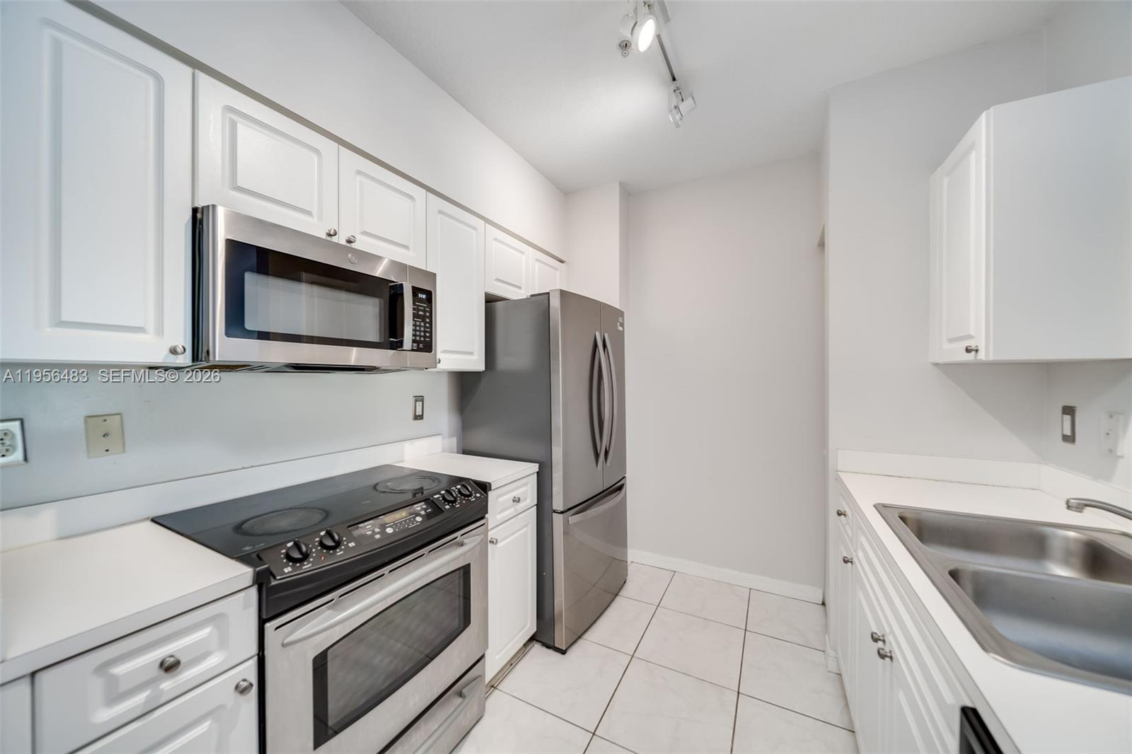 a kitchen with stainless steel appliances granite countertop white cabinets a stove top oven a sink and dishwasher
