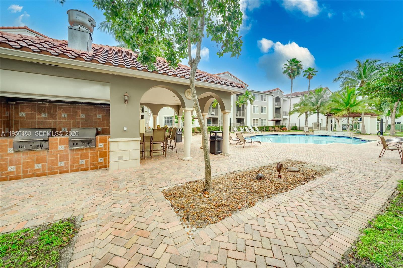 6831 Southwest 44th Street, Unit 304 Miami, FL 33155 - Photo 14 of 27 a view of a swimming pool with outdoor seating
