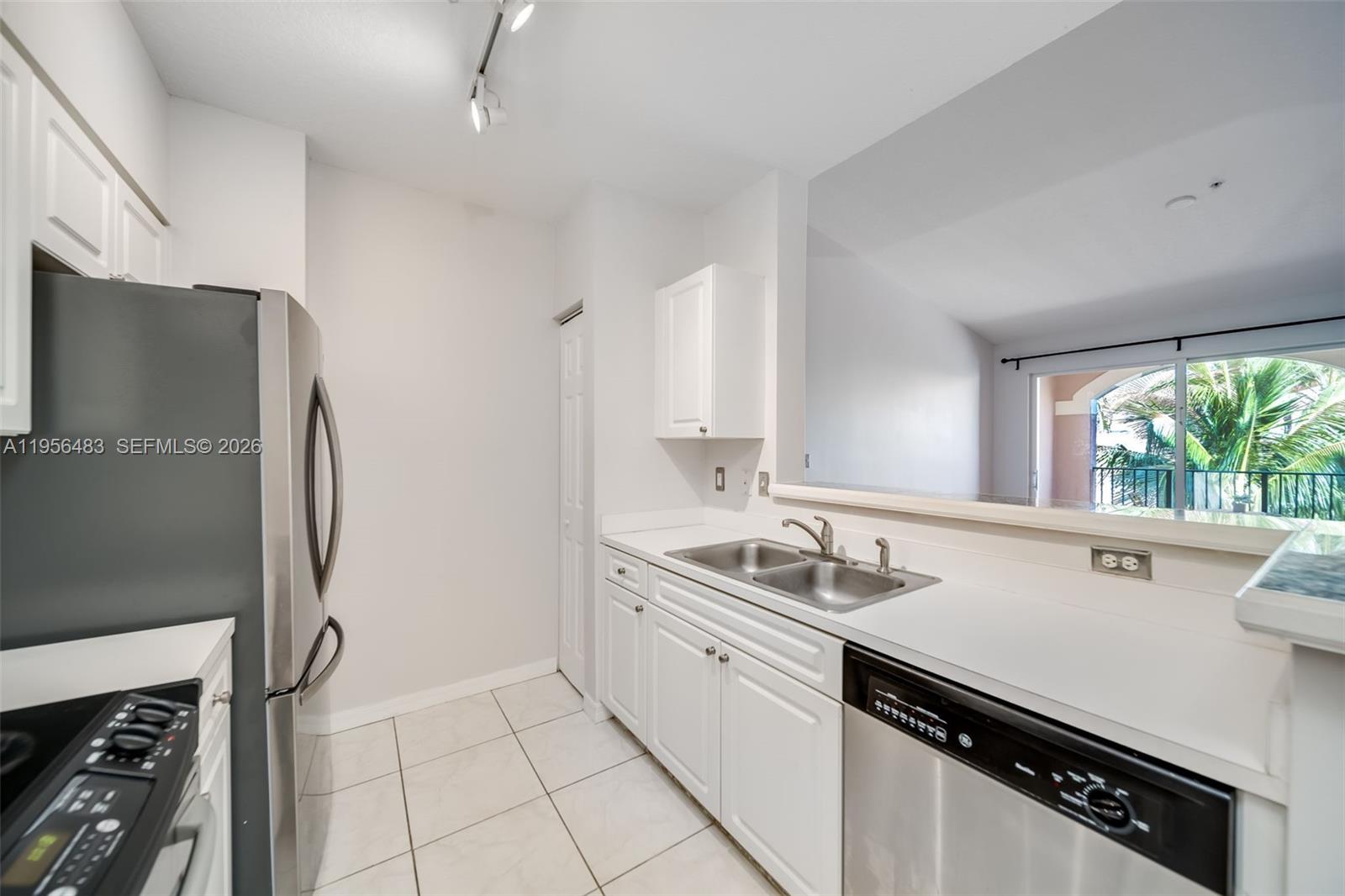 6831 Southwest 44th Street, Unit 304 Miami, FL 33155 - Photo 2 of 27 a kitchen with a sink appliances and cabinets