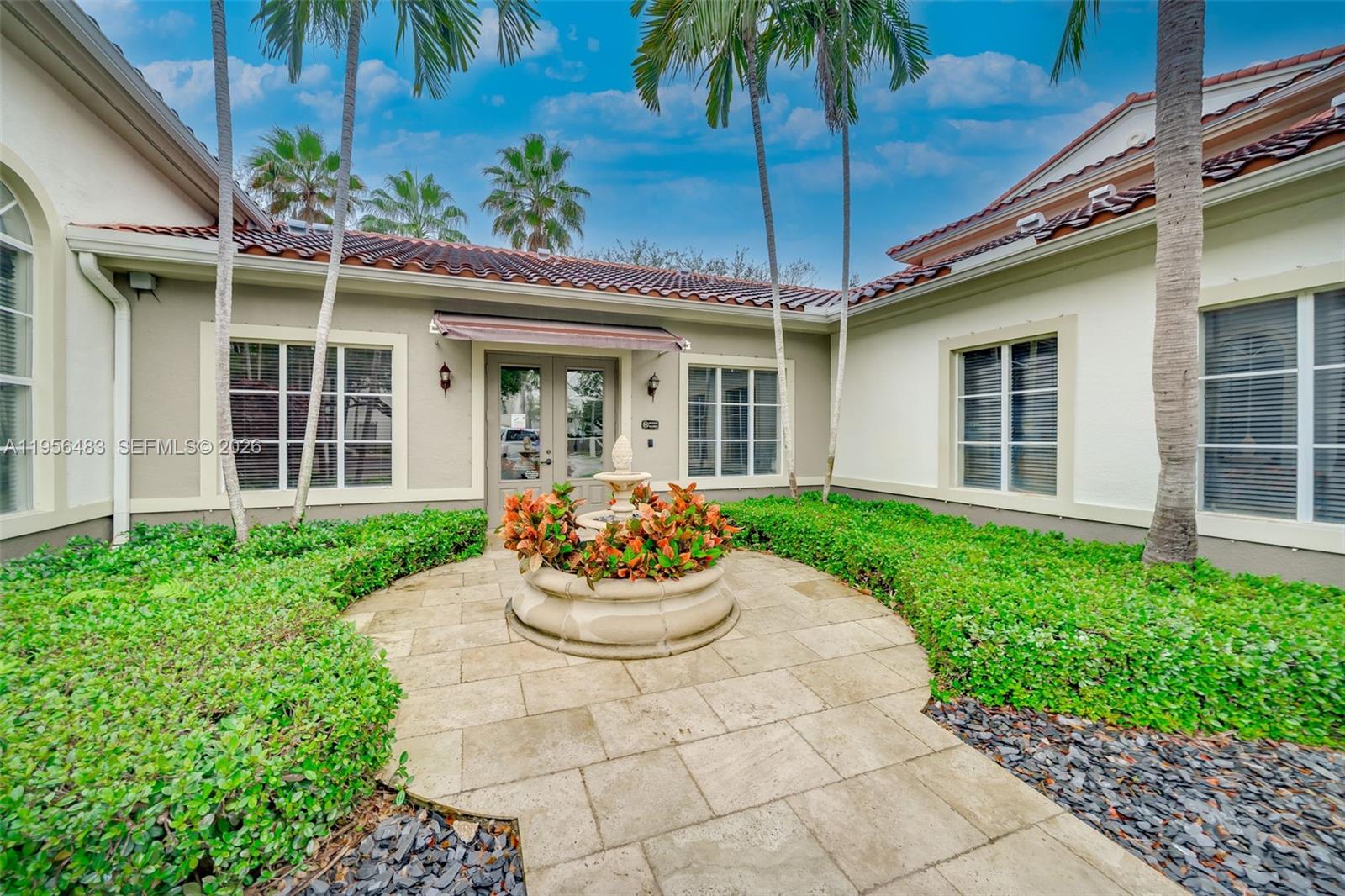 6831 Southwest 44th Street, Unit 304 Miami, FL 33155 - Photo 23 of 27 a front view of a house with a garden and patio