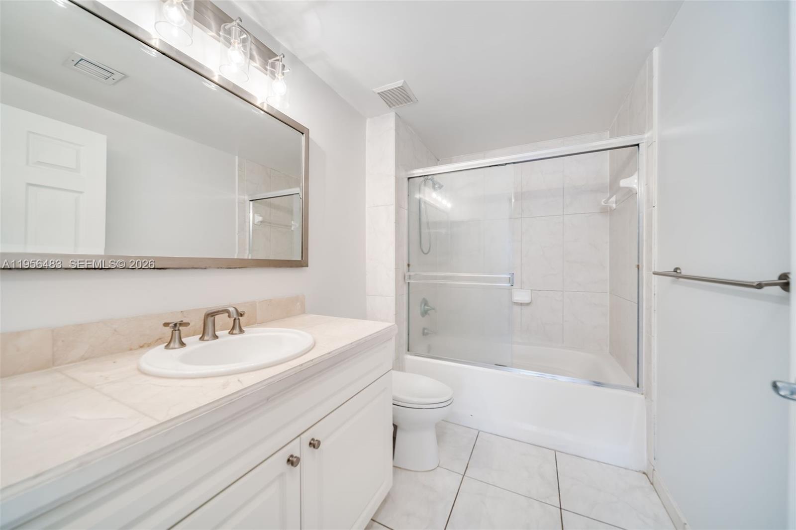 6831 Southwest 44th Street, Unit 304 Miami, FL 33155 - Photo 6 of 27 a bathroom with a shower sink vanity mirror and toilet