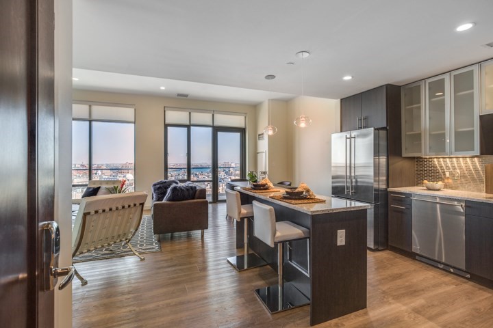 1 Canal Street, Unit PH1203 Boston, MA 02114 - Photo 2 of 17 a view of a kitchen with kitchen island granite countertop a table chairs sink and wooden floor