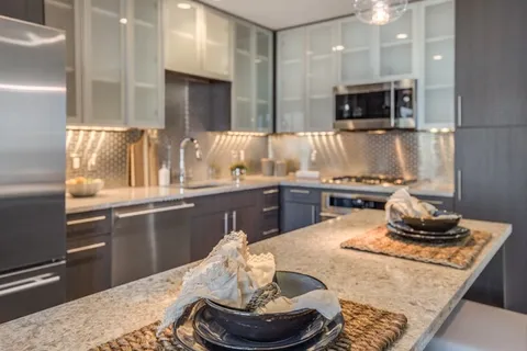a kitchen with kitchen island granite countertop a sink and a stove