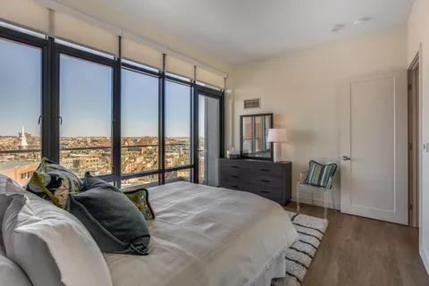 a bedroom with furniture and a large window