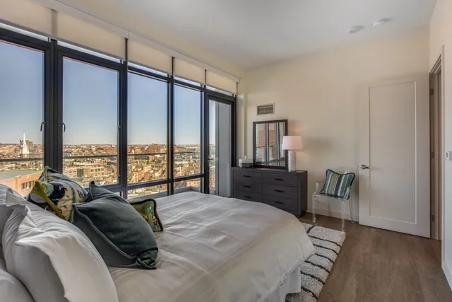 a bedroom with furniture and a large window