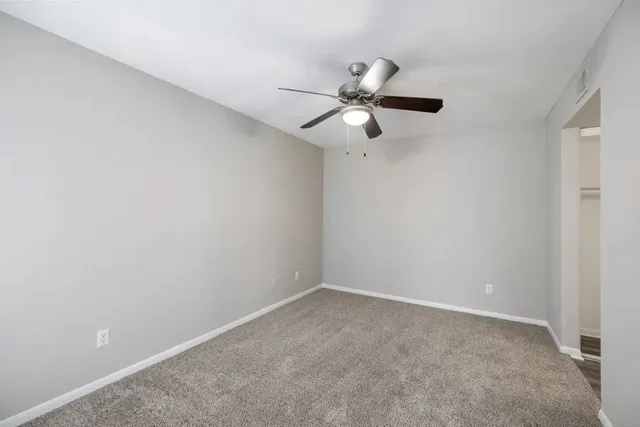 an empty room with a fan and a fan