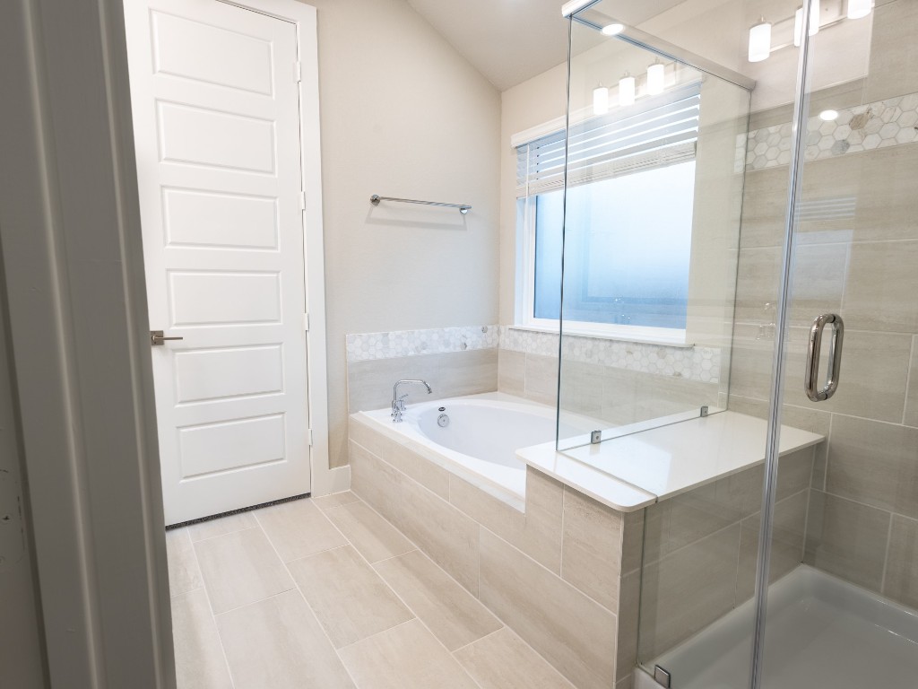 2010 Bluff Oak Street Conroe, TX 77304 - Photo 23 of 35 a bathroom with a tub a sink and a large mirror