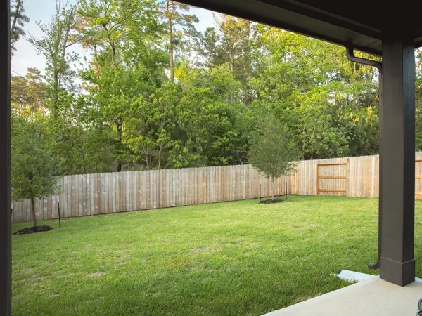 a view of a yard in front of a house with large trees