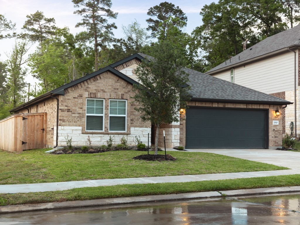 2010 Bluff Oak Street Conroe, TX 77304 - Photo 33 of 35 a front view of a house with a yard and garage