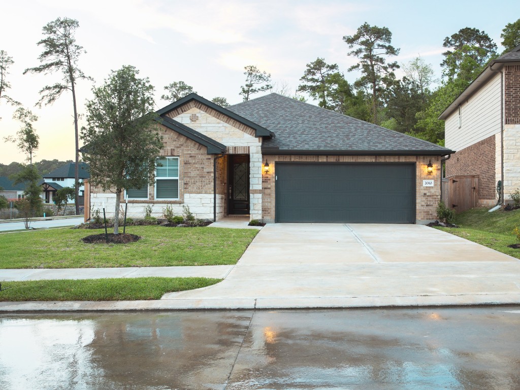 2010 Bluff Oak Street Conroe, TX 77304 - Photo 34 of 35 a front view of a house with a garden and trees
