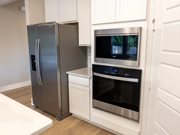 a kitchen with granite countertop white cabinets and stainless steel appliances