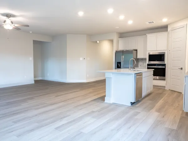 a view of kitchen with wooden floor and electronic appliances
