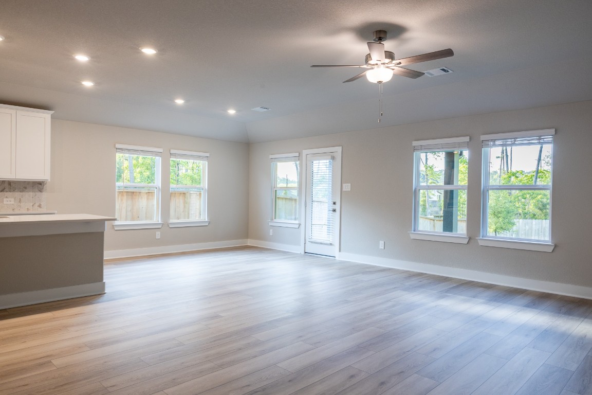 2010 Bluff Oak Street Conroe, TX 77304 - Photo 9 of 35 a view of an empty room with a window and wooden floor