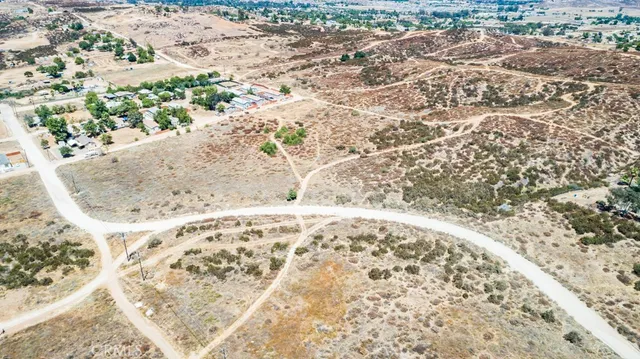 a view of a dry yard with wooden fence
