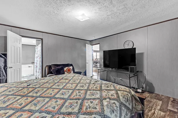 a bedroom with a bed and a flat screen tv