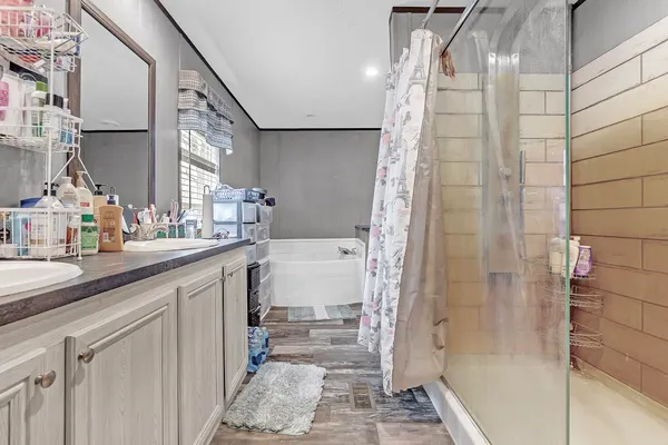 a bathroom with a double vanity sink a mirror and shower