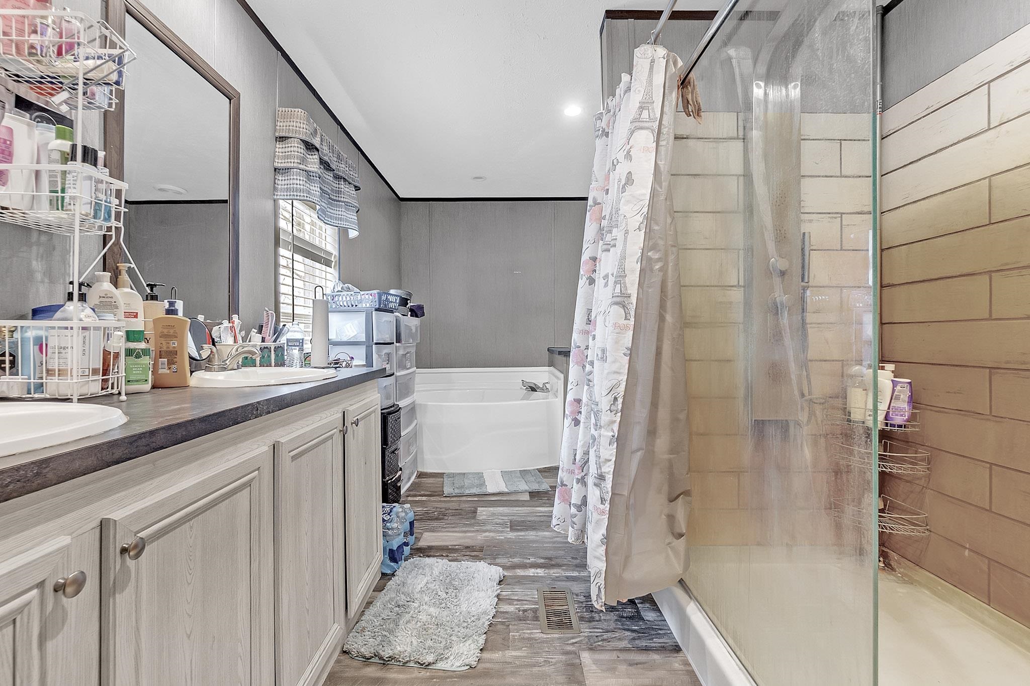 664 Rialto Road Covington, TN 38019 - Photo 12 of 22 Bathroom with a stall shower, double vanity, a bath, and light wood-style flooring