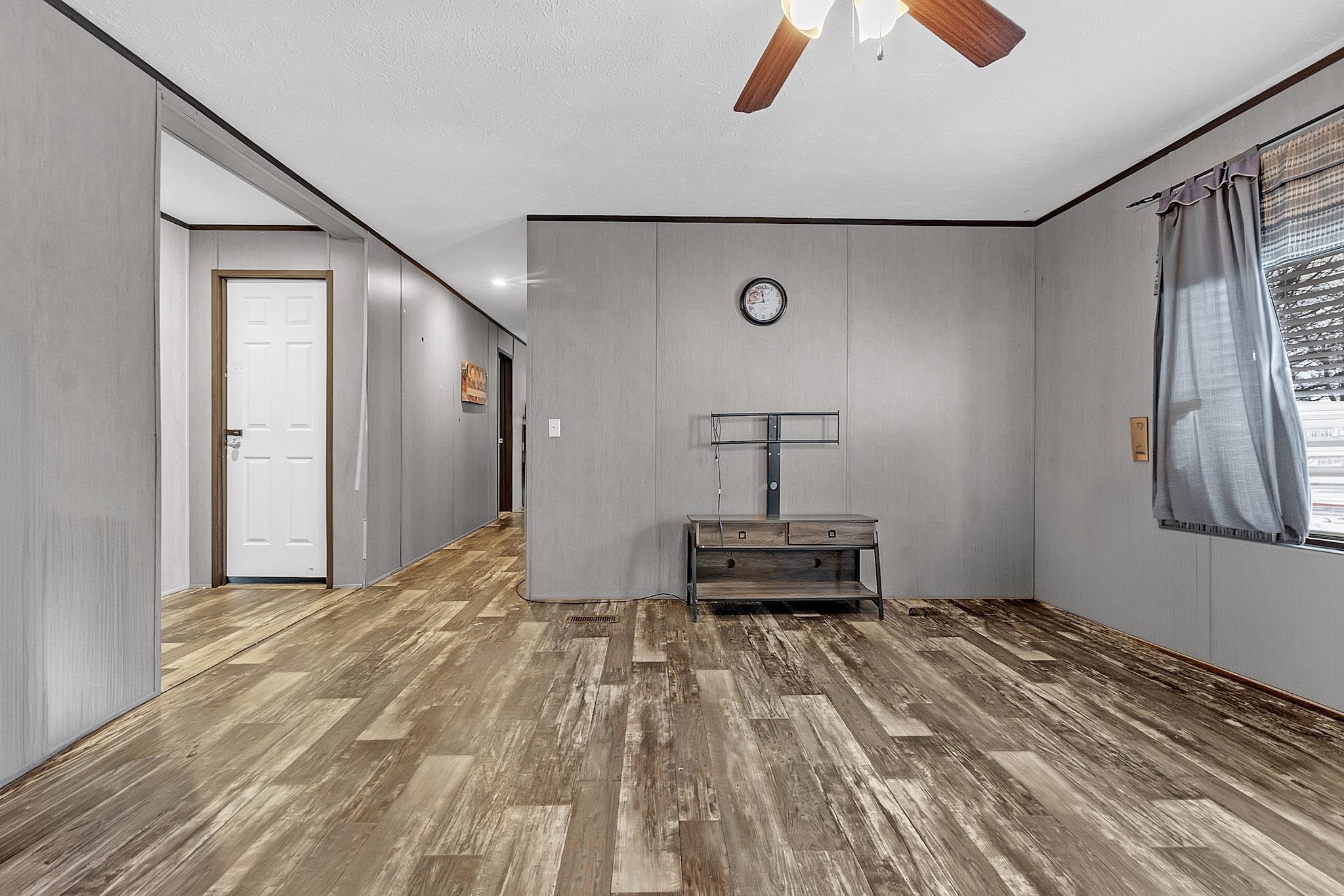 664 Rialto Road Covington, TN 38019 - Photo 18 of 22 Unfurnished living room featuring a ceiling fan, wood finished floors, and crown molding