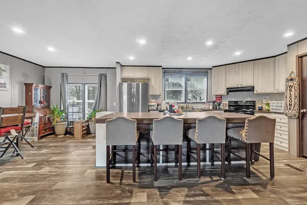 a kitchen with stainless steel appliances granite countertop a stove a sink a dining table and chairs