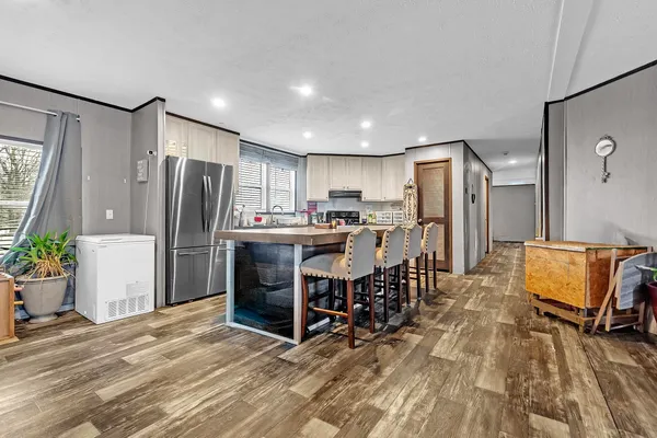 a kitchen with refrigerator and chairs