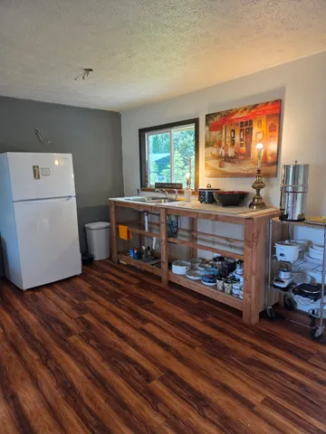 a kitchen with a stove and wooden floor