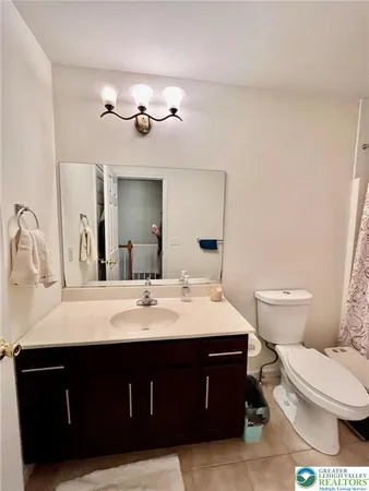 a bathroom with a sink vanity mirror and toilet