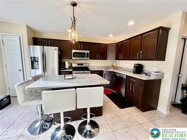 a kitchen with stainless steel appliances a stove a sink a microwave a refrigerator and cabinets