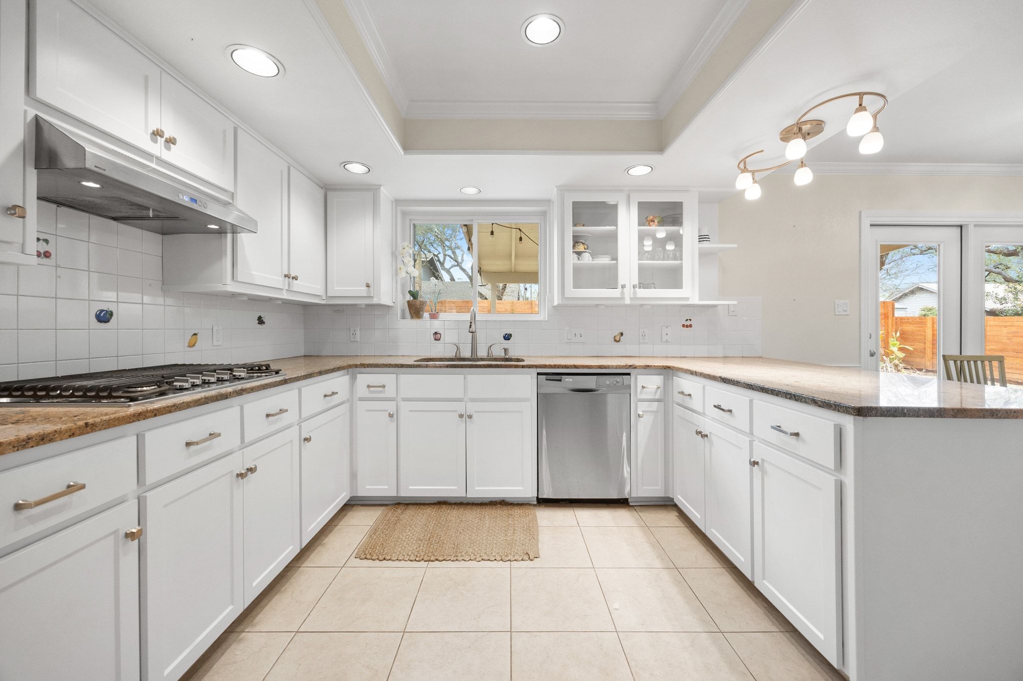 11204 Deadoak Lane Austin, TX 78759 - Photo 15 of 40 a large kitchen with granite countertop a sink white cabinets and stainless steel appliances