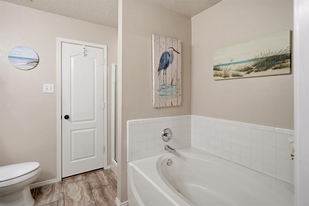 1213 Hampton Drive Forney, TX 75126 - Photo 19 of 27 a white bath tub sitting next to a toilet