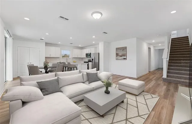 a living room with furniture kitchen view and a table