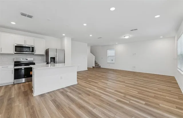 a view of kitchen with wooden floor and electronic appliances