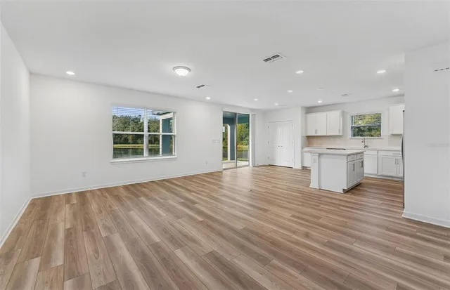 a view of empty room with wooden floor and windows